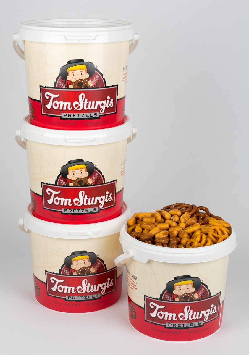 Stack of plastic tubs with logo. One tub filled with pretzels.